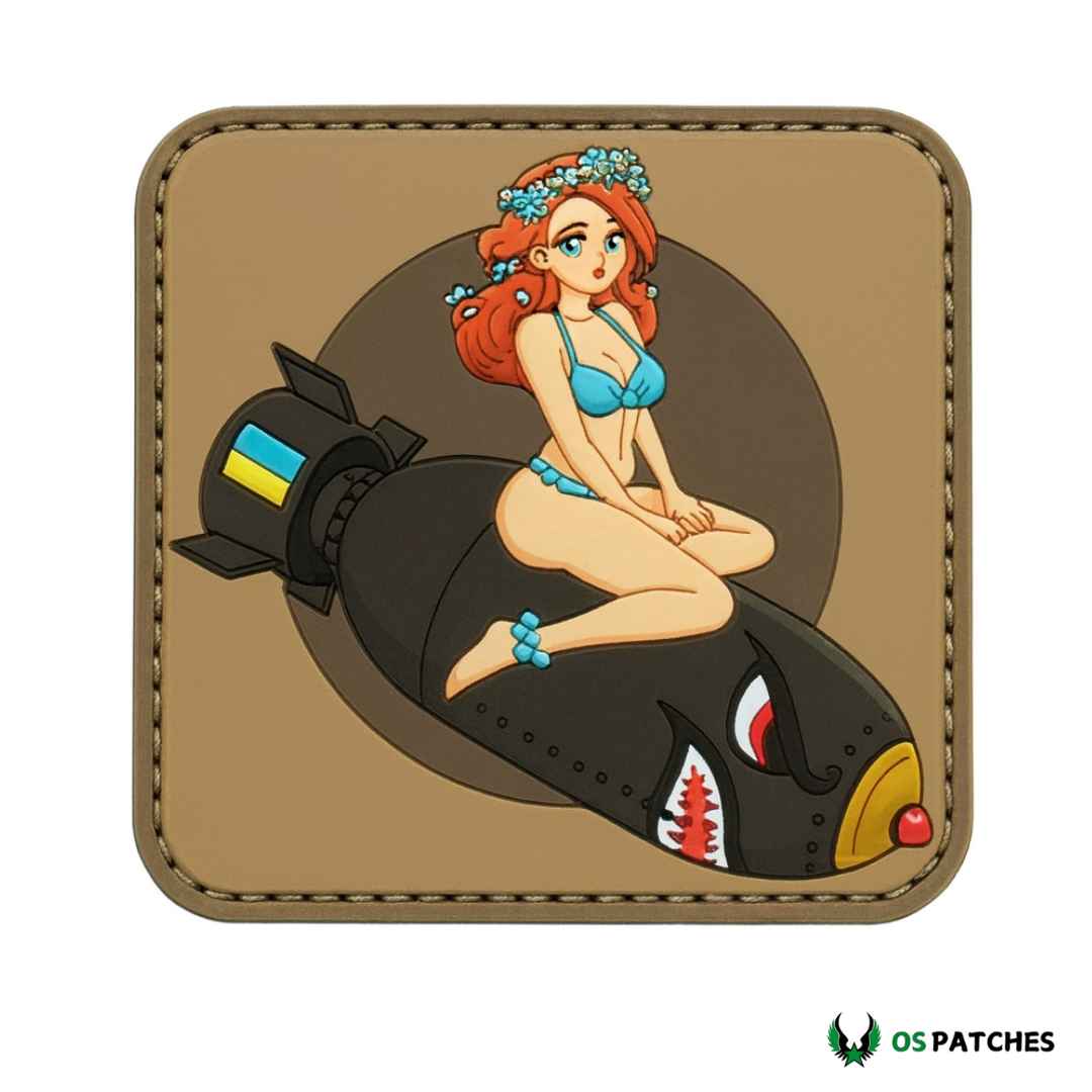 Chica pelirroja en bikini azul sentada sobre bomba táctica estilo pin-up