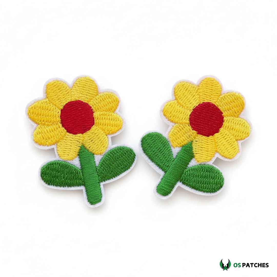 Par de parches bordados con flores amarillas, centro rojo y hojas verdes, ideales para decorar ropa o accesorios.